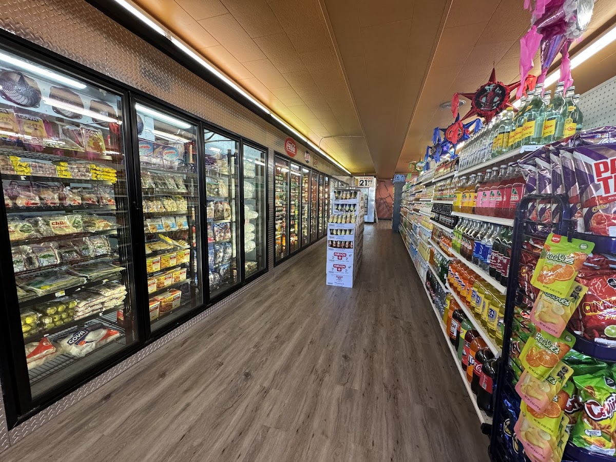 Refrigerated meat and deli cases down the aisle at Julissa's Meat Market